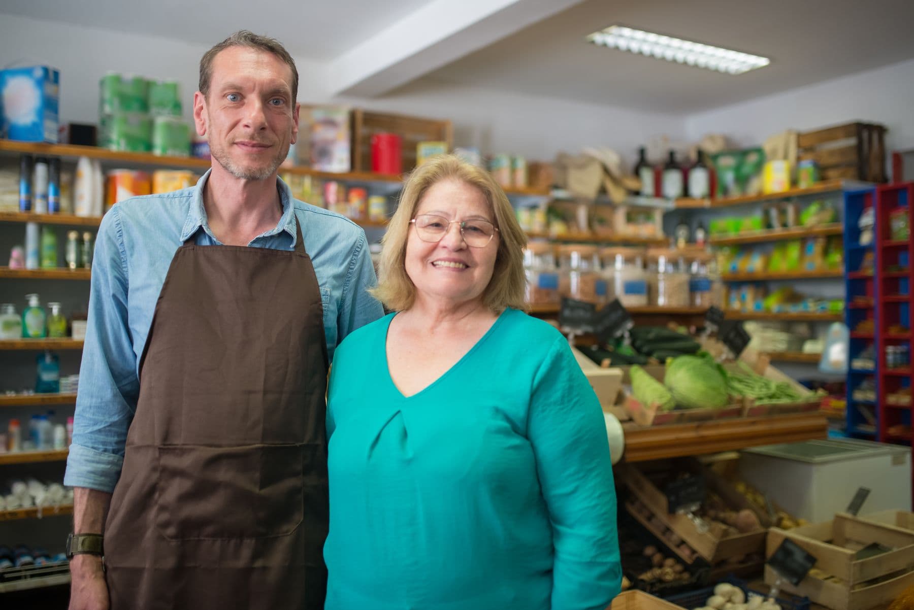 Two people posing inside a grocery store